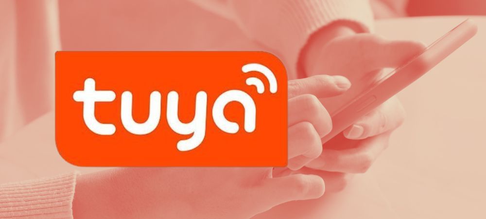 Het logo van Tuya met een smart phone in de achtergrond.
