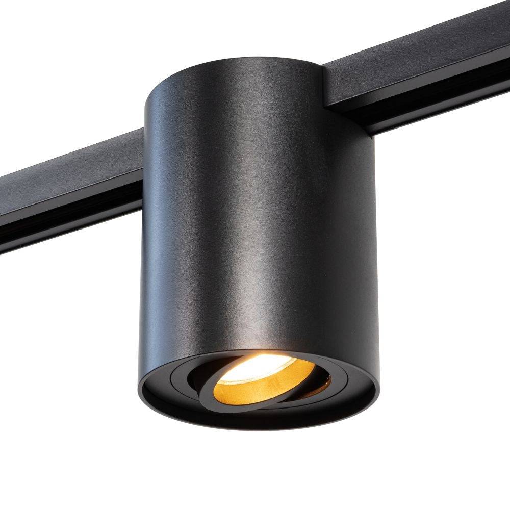 Zwarte railspot met ronde lens en warme lichtbundel