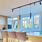 Zwarte rail hanglamp met lange buis en enkele fitting, hangend aan het railsysteem