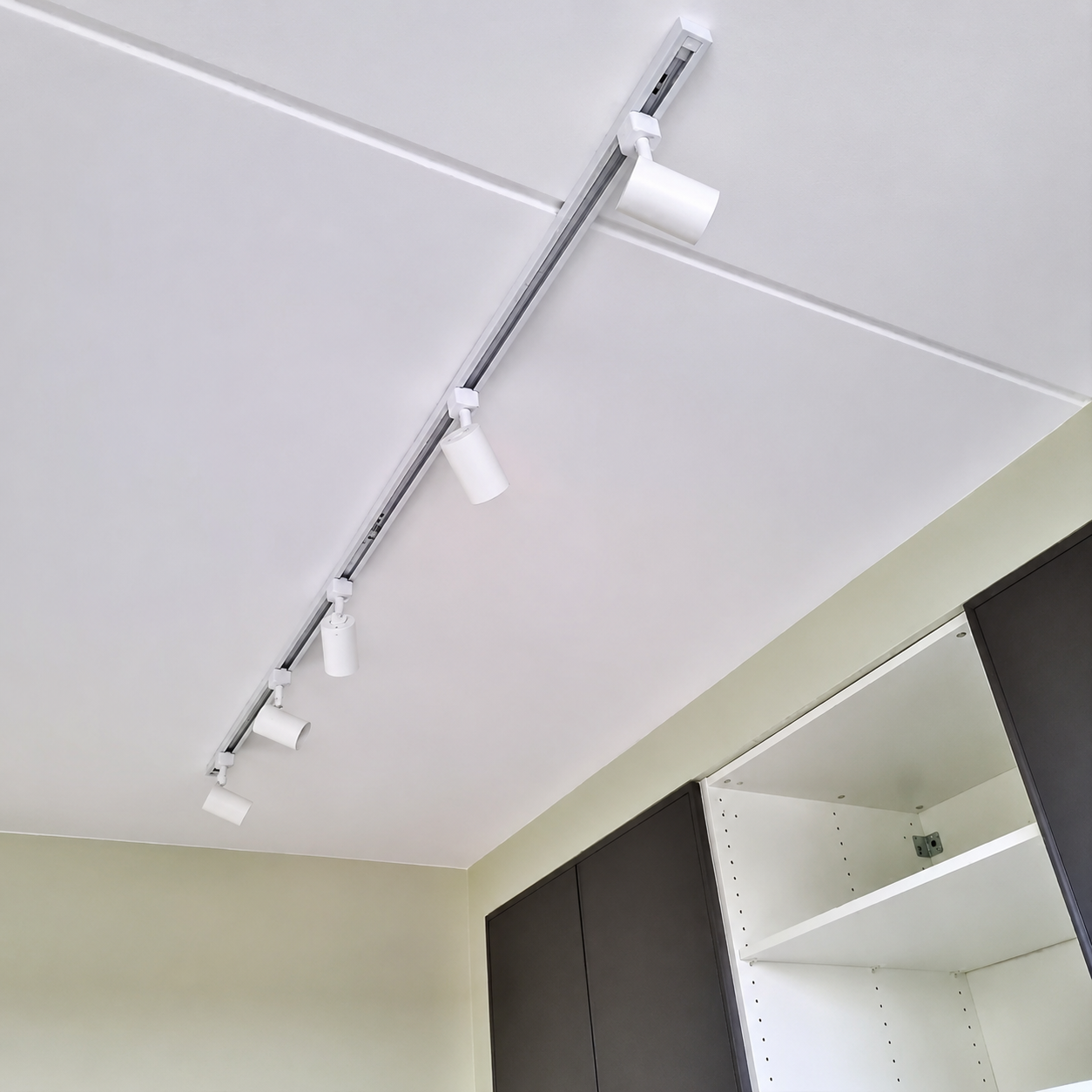 Witte railverlichting met meerdere GU10 spots op het plafond