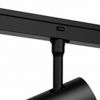 Zwarte railspot op rail, met kantelbare behuizing en lensopening.