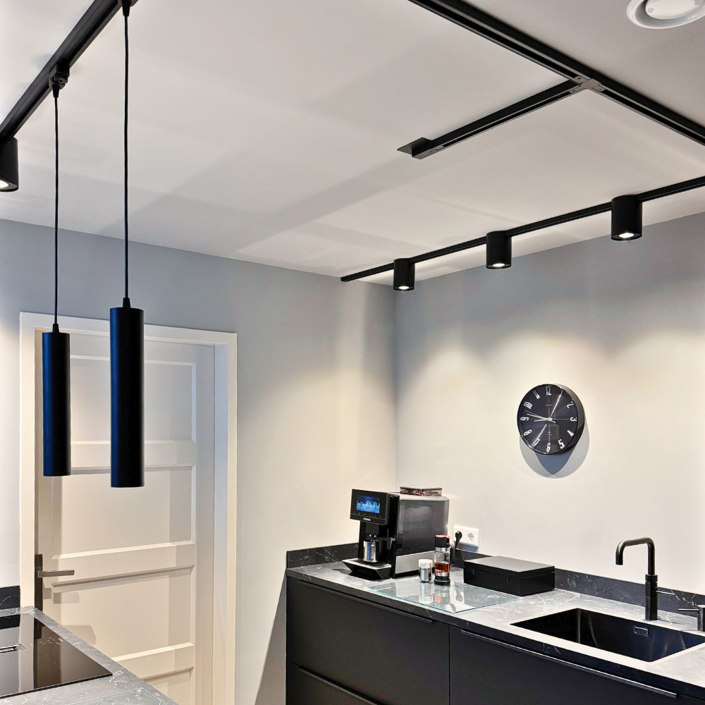 Plafond railverlichting met zwarte stang en meerdere spots voor gerichte verlichting