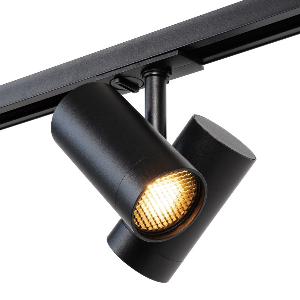 Zwarte railspot met warm verlichte lens en draaibare behuizing