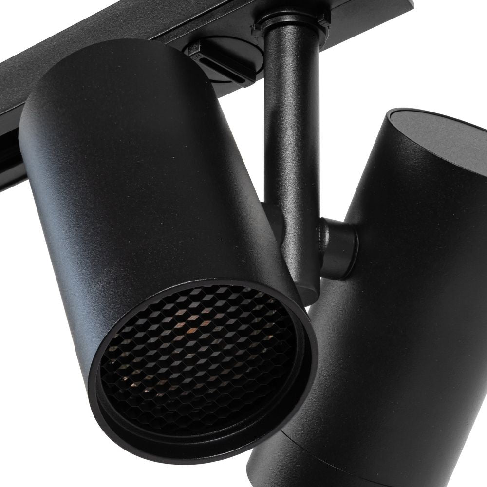 Zwarte railspot met geperforeerde lens voor warm licht.