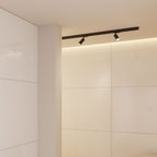 Zwarte rail met LED-spots op plafond; strak en minimalistisch