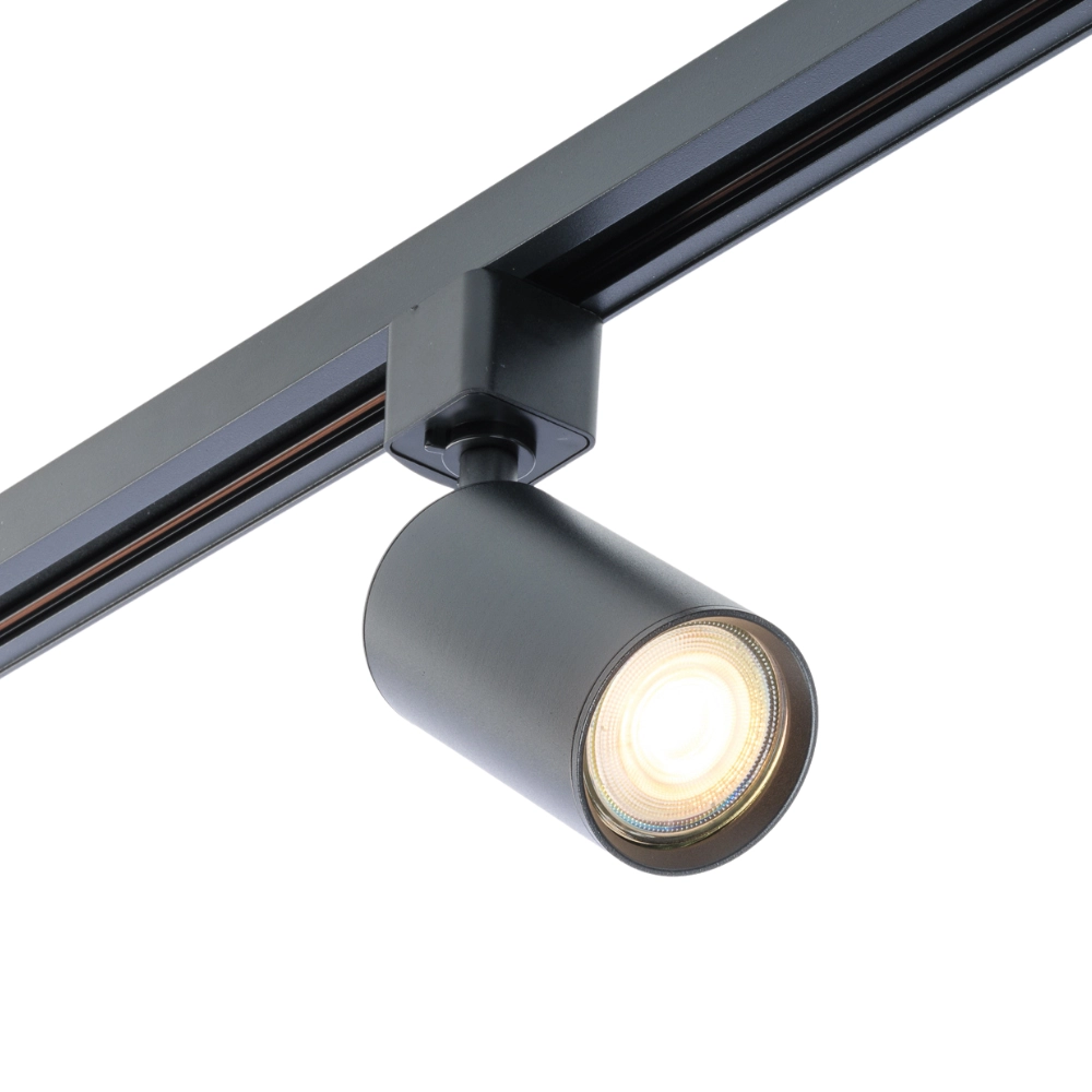Zwarte cylindrische GU10 spot op rail met warm brandend licht.